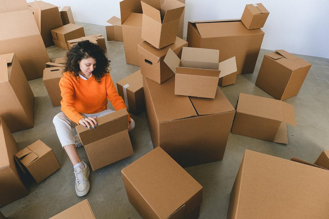 a woman preparing boxes as a way to declutter your home before the move